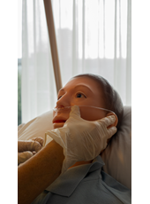 Een deelnemer brengt een zuurstof neusbril aan bij een patiënt om deze vrh te laten aftoetsen 